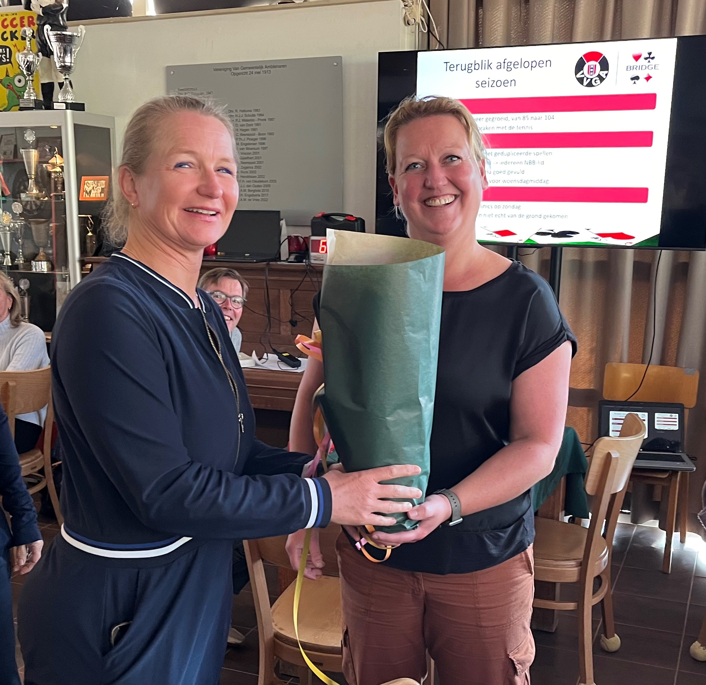 Paula List-Talman (links) krijgt een bloemetje van Vanessa de Weger, voorzitter van de bridgecommissie. 
